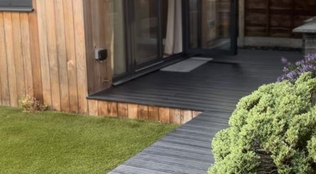 Tranquil patio at Sculpt Labs - Marple, Stockport, England with lush greenery and wooden exterior.
