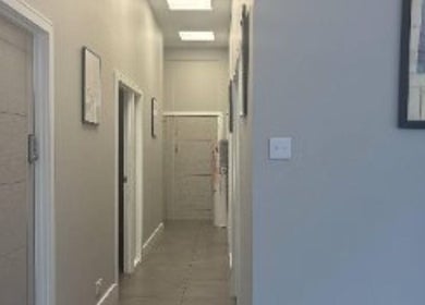 Elegant hallway at The Metropolis Massage, Surbiton, England, GB, featuring modern decor and soft lighting.