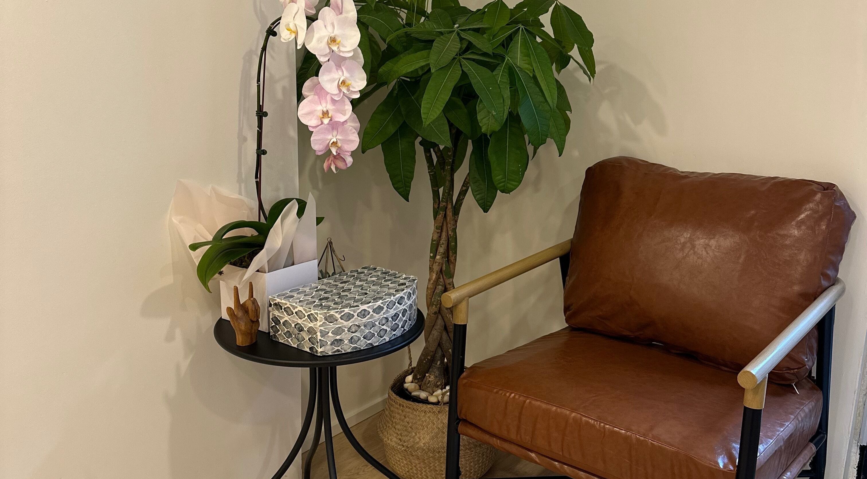 Cozy lounge chair and orchids at Studio Enu, Toronto, Ontario, CA, embody relaxation and elegance.