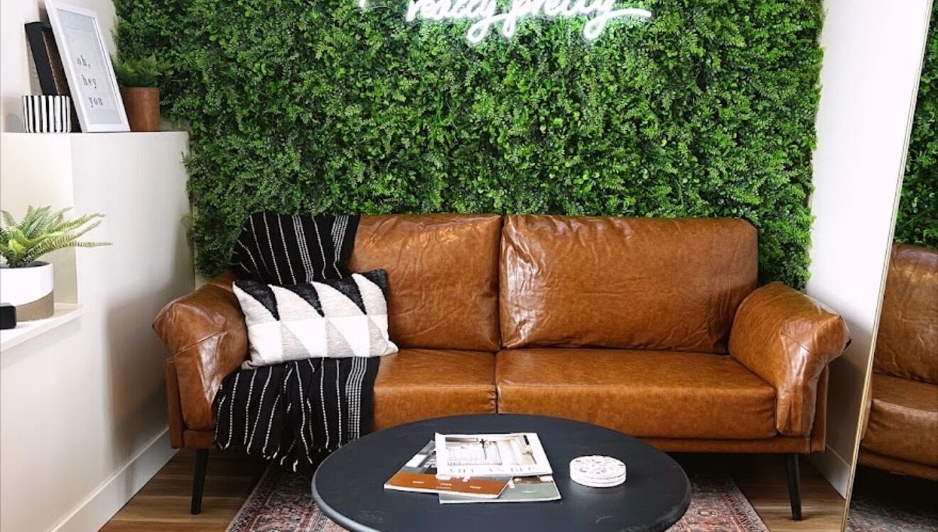 Cozy brown leather sofa with greenery at Sol Aesthetics-Hastings, Hastings, Minnesota, US.