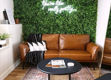 Cozy brown leather sofa with greenery at Sol Aesthetics-Hastings, Hastings, Minnesota, US.