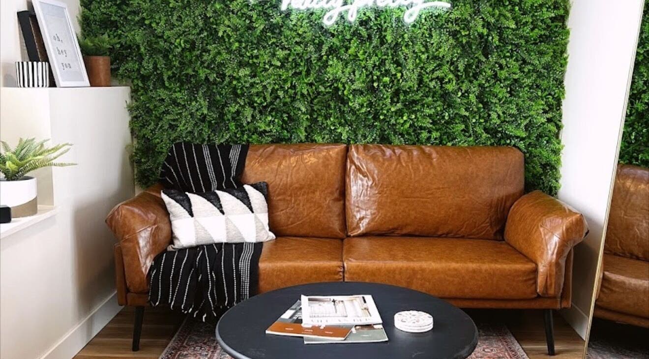 Cozy brown leather sofa with greenery at Sol Aesthetics-Hastings, Hastings, Minnesota, US.