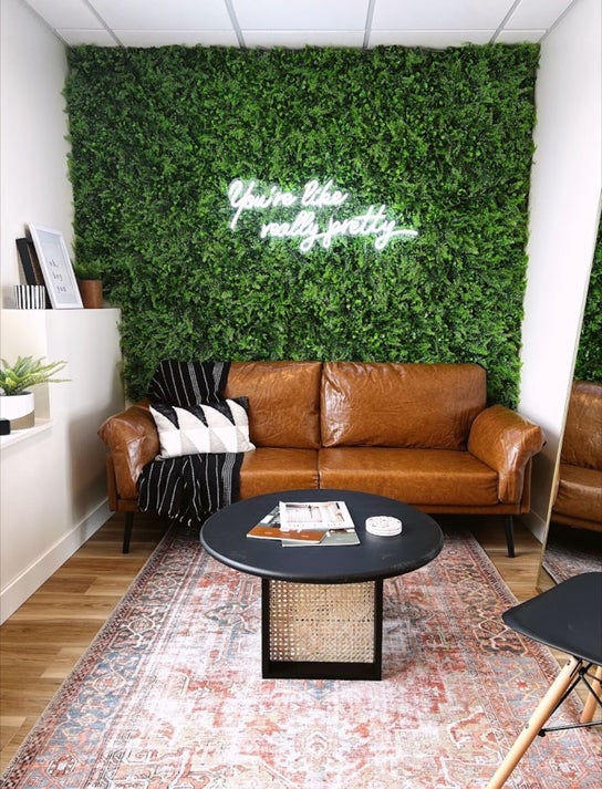 Cozy brown leather sofa with greenery at Sol Aesthetics-Hastings, Hastings, Minnesota, US.