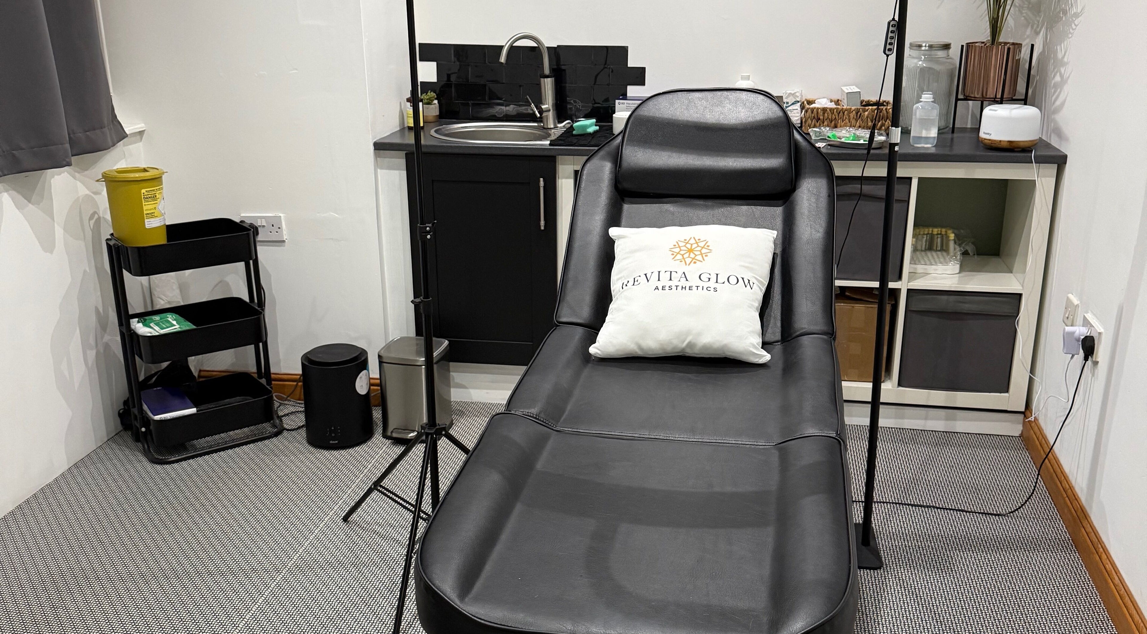 Modern treatment room at Revitaglow Aesthetics and Wellness, Derby, England, GB, featuring a sleek black therapy bed.