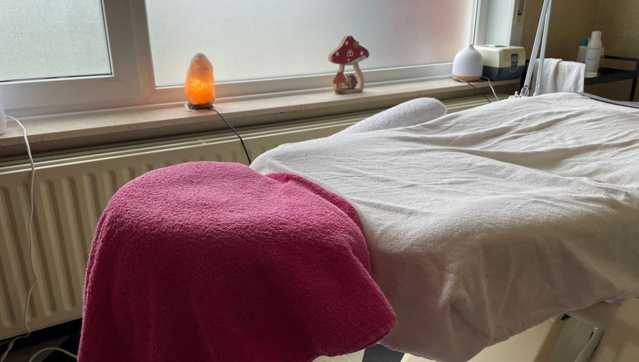 Massage tafel bij Beauty Spot Roos in Dessel, Vlaanderen, BE met roze handdoek en zoutlamp.