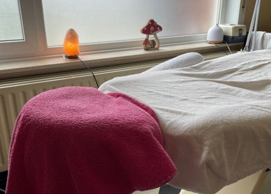 Massage tafel bij Beauty Spot Roos in Dessel, Vlaanderen, BE met roze handdoek en zoutlamp.