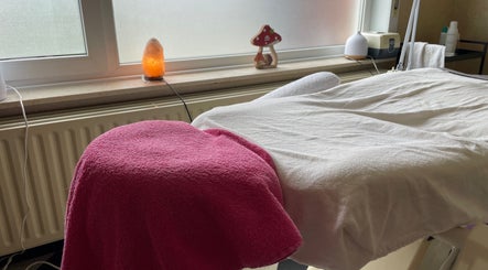 Massage tafel bij Beauty Spot Roos in Dessel, Vlaanderen, BE met roze handdoek en zoutlamp.