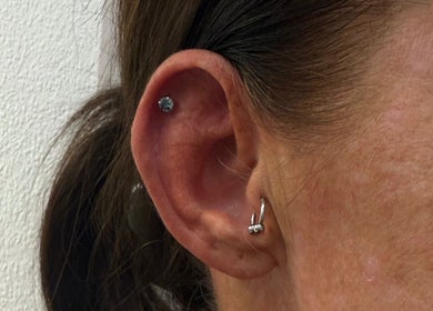 Ear piercings with silver jewelry at Pure Aura Studio, Hindley Green, England, GB.