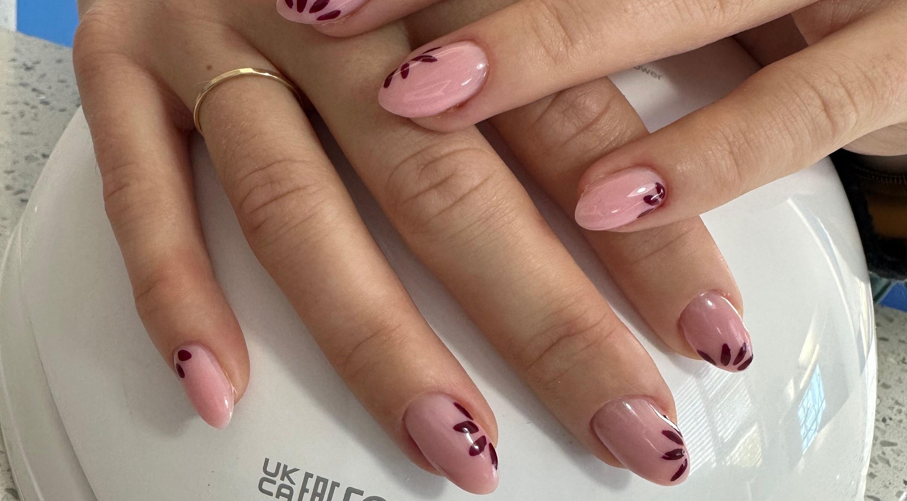 Detailed nail art at Lee Glamour Nails in Pretoria, Gauteng, ZA featuring elegant pink polish with leaf accents.
