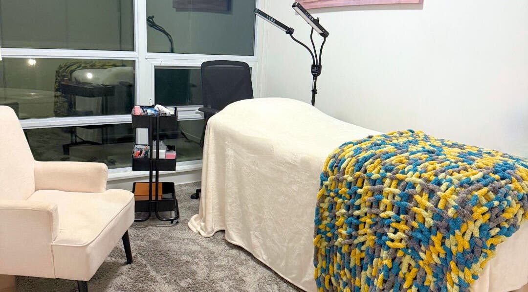 Cozy treatment room at Winked Studio, Toronto, Ontario, CA with plush chair and colorful blanket.
