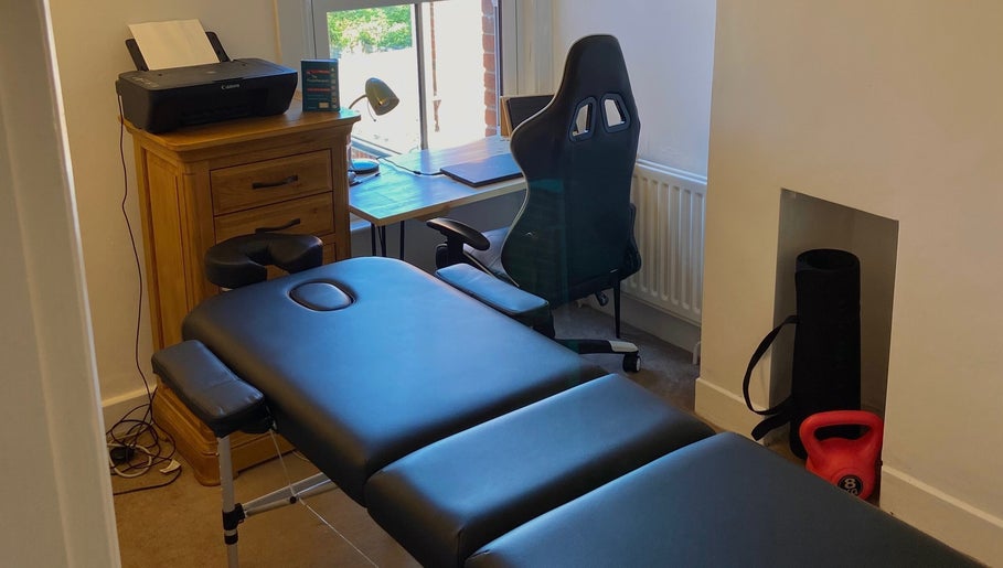 Therapy room at Kinetiq Therapy, Colchester, England, GB featuring a massage table and desk for holistic treatments.