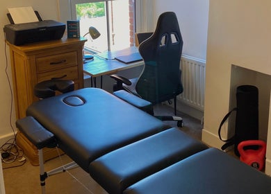 Therapy room at Kinetiq Therapy, Colchester, England, GB featuring a massage table and desk for holistic treatments.