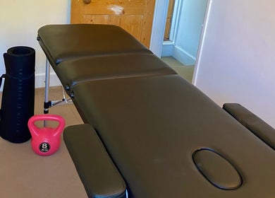 Therapy room at Kinetiq Therapy in Colchester, England, GB featuring massage table and exercise equipment.