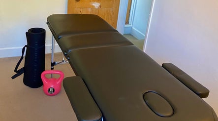 Therapy room at Kinetiq Therapy in Colchester, England, GB featuring massage table and exercise equipment.