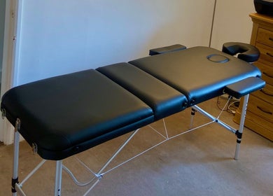 Massage table at Kinetiq Therapy in Colchester, England, GB, offering a serene wellness environment.