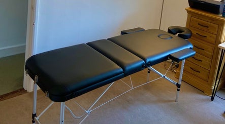 Massage table at Kinetiq Therapy in Colchester, England, GB, offering a serene wellness environment.