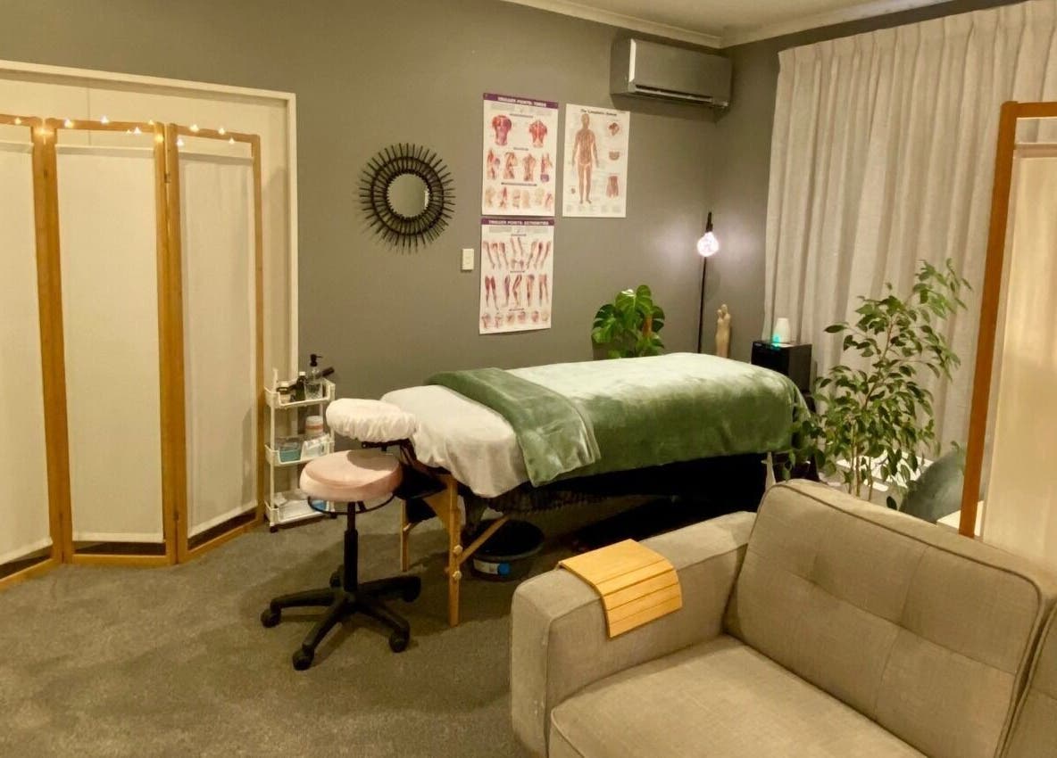Relaxing therapy room at Muscles & Mind, Hamilton, Waikato Region, NZ, featuring a massage table and cozy decor.