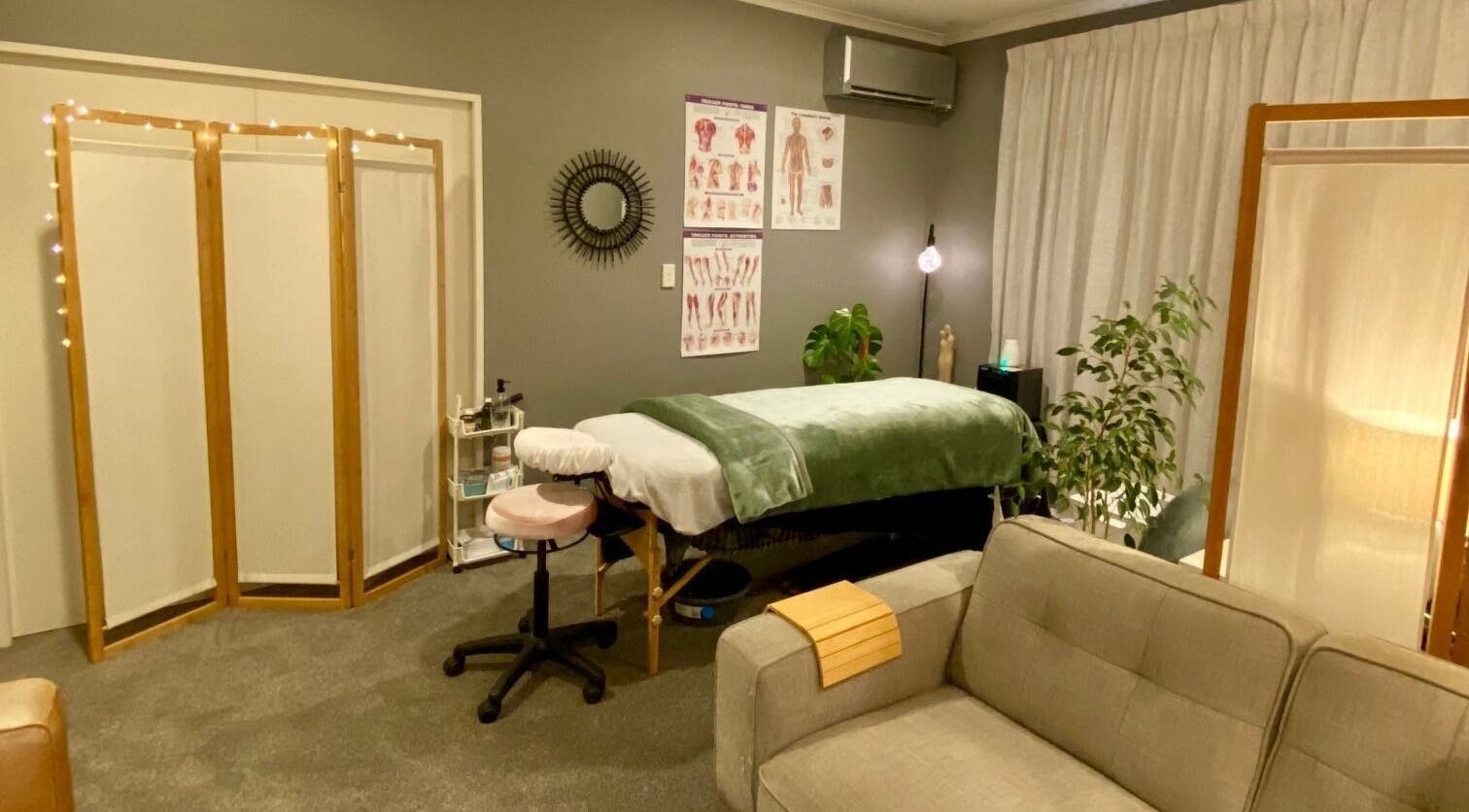 Relaxing therapy room at Muscles & Mind, Hamilton, Waikato Region, NZ, featuring a massage table and cozy decor.