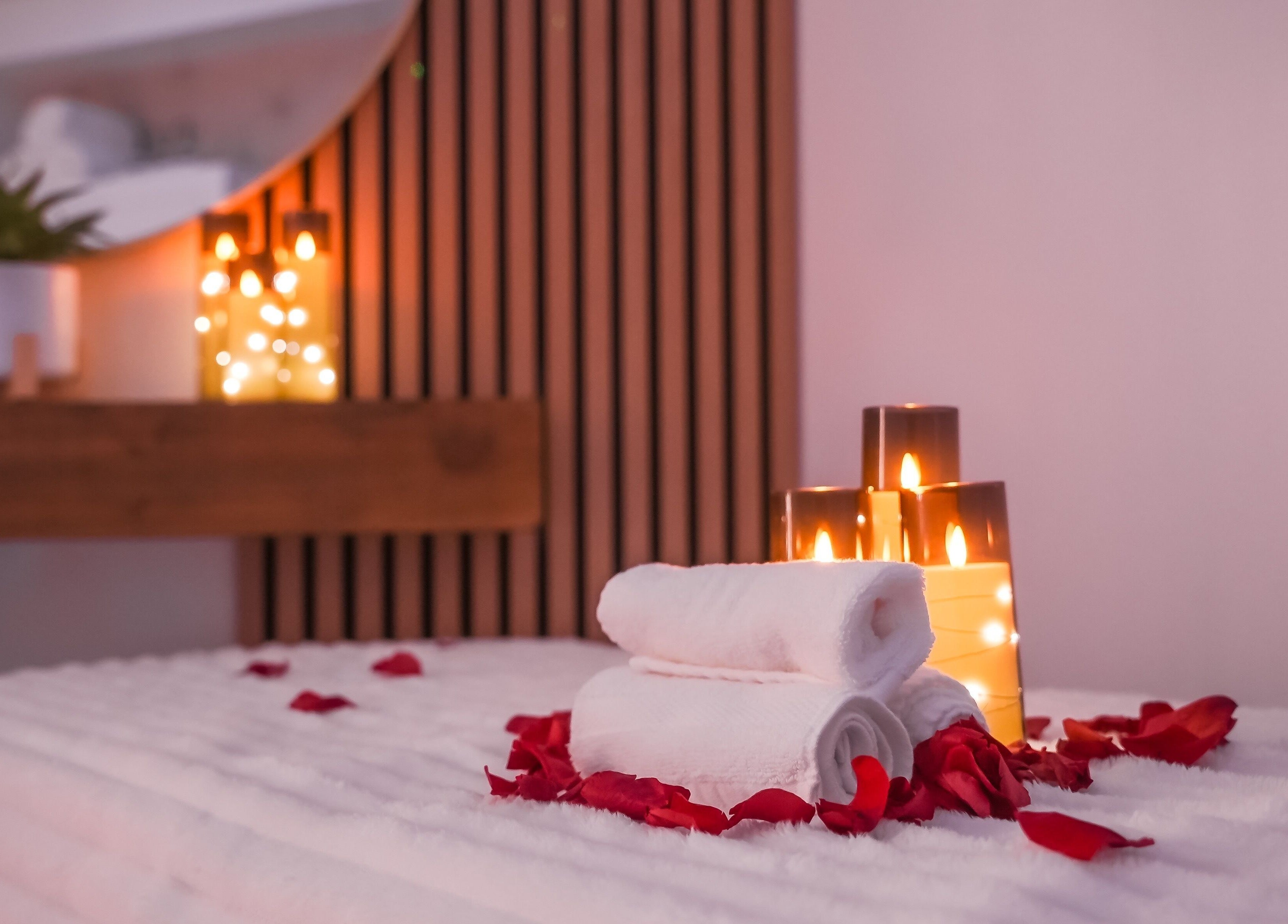 Luxurious spa setup at Lavie Bella Head Spa, Artesia, California, US with candles, towels, and petals.