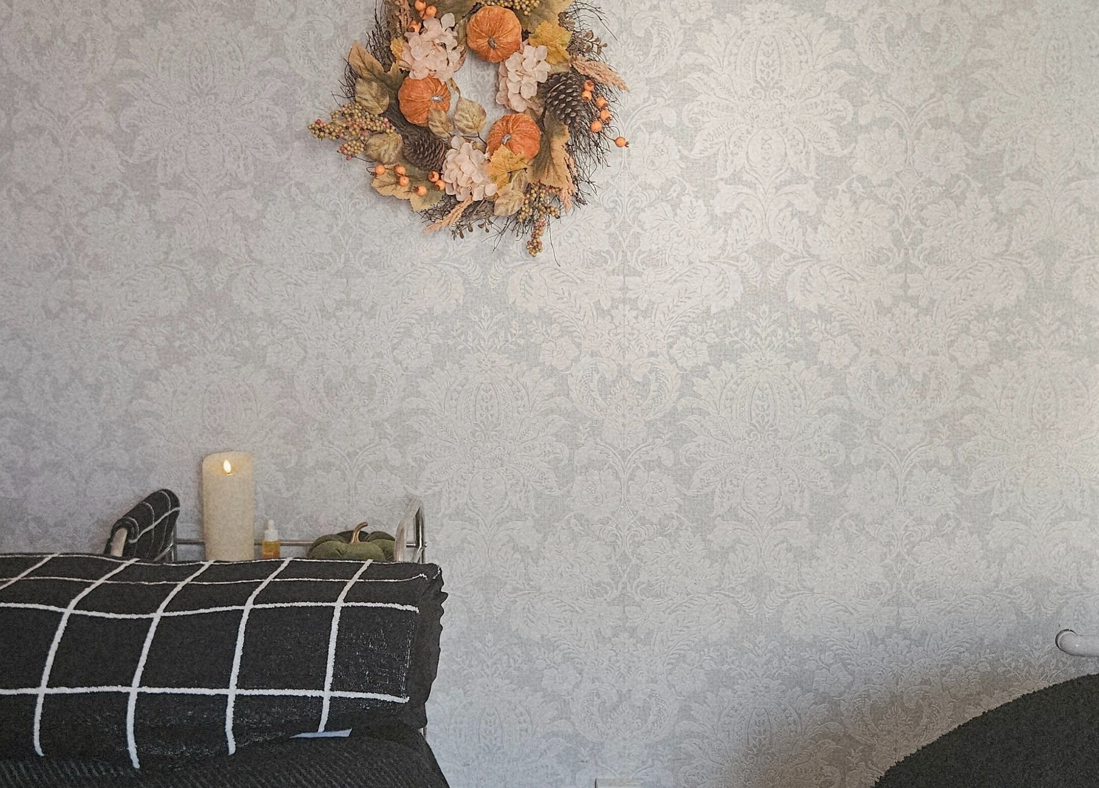 Elegant room at LMT Beauty By Lauren, Chichester, England, GB with a floral wreath and soothing candles.