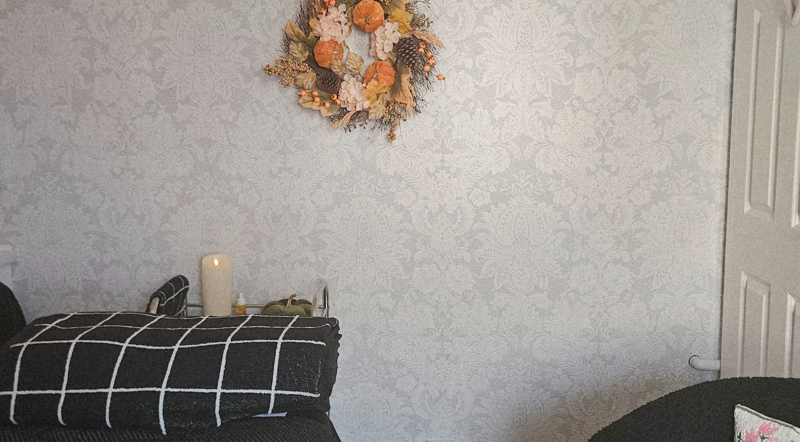 Elegant room at LMT Beauty By Lauren, Chichester, England, GB with a floral wreath and soothing candles.