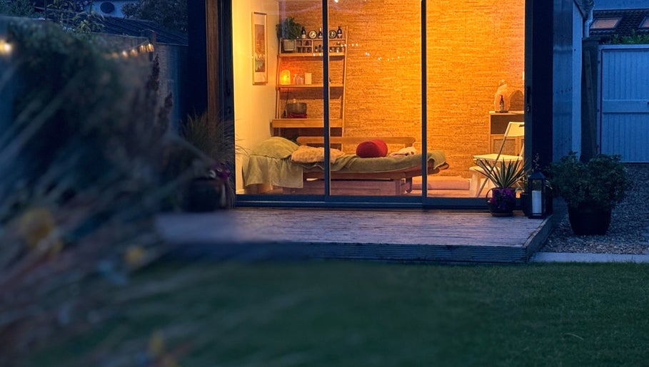 Cozy massage room at Little Zen Reflexology, Bristol, England. Warm lighting showcases relaxation ambiance.