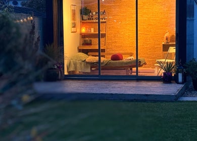 Cozy massage room at Little Zen Reflexology, Bristol, England. Warm lighting showcases relaxation ambiance.