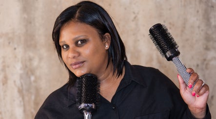 Professional hairstylist at Kymric Hall, Franschhoek, Western Cape, ZA, holding round brushes for hair styling.