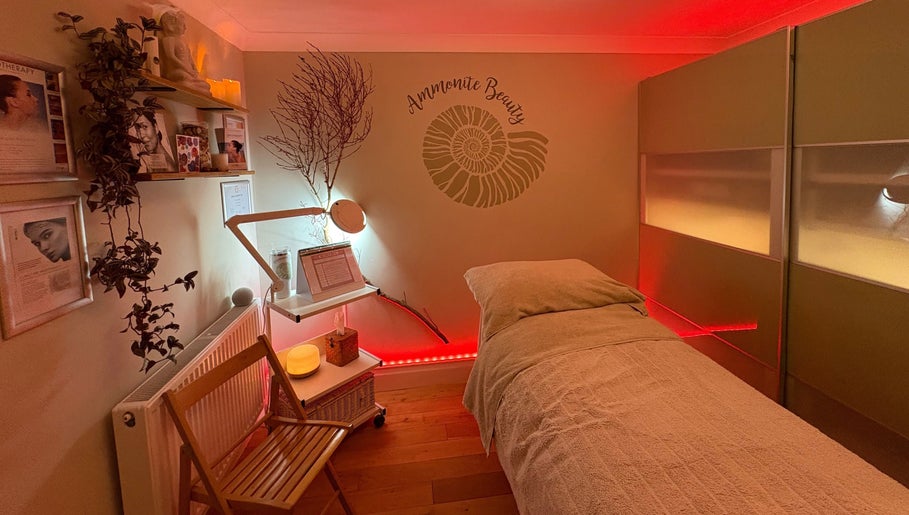 Relaxing treatment room at Ammonite Beauty in Bridport, England, GB, featuring soothing lighting and decor.