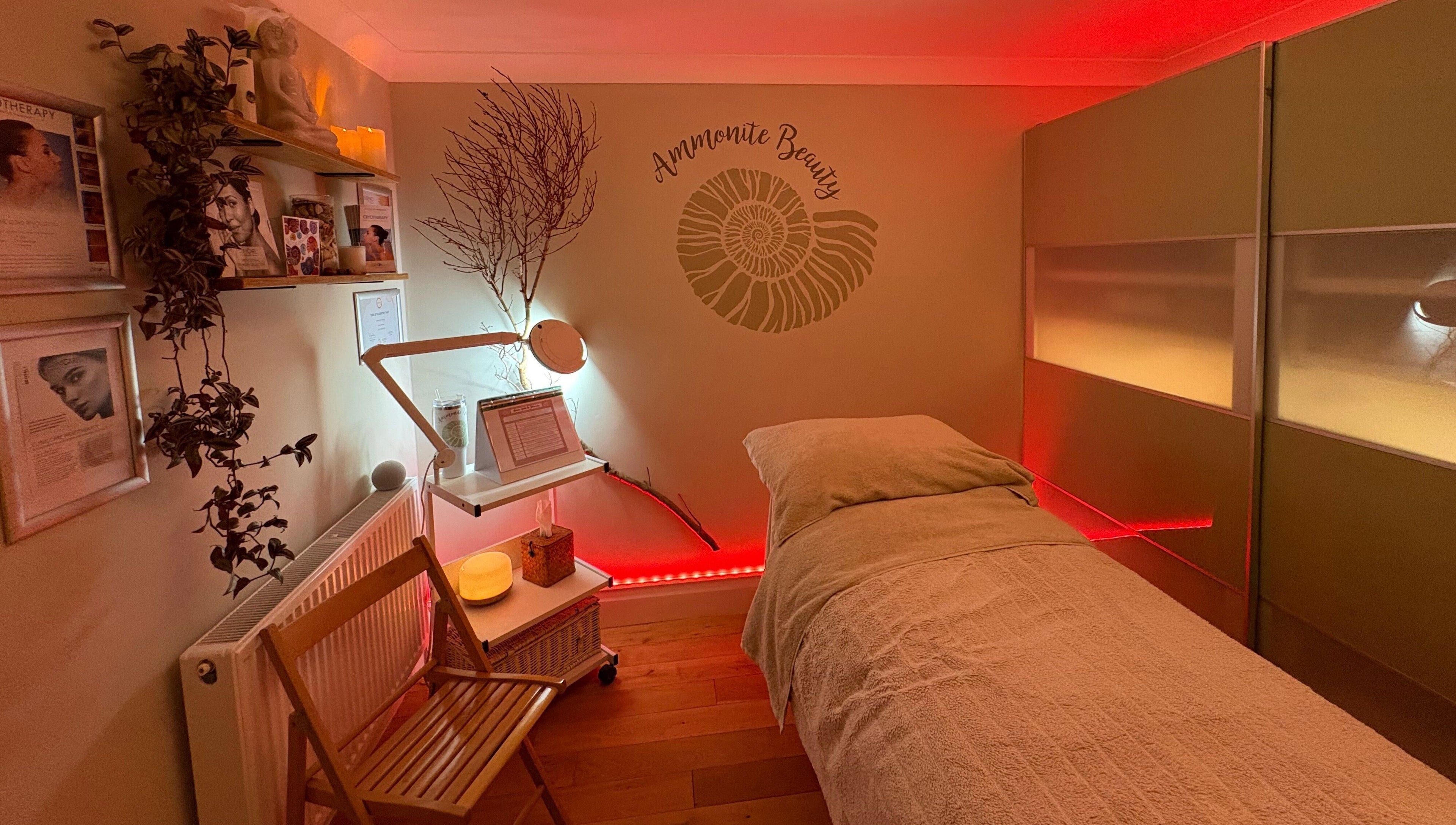 Relaxing treatment room at Ammonite Beauty in Bridport, England, GB, featuring soothing lighting and decor.