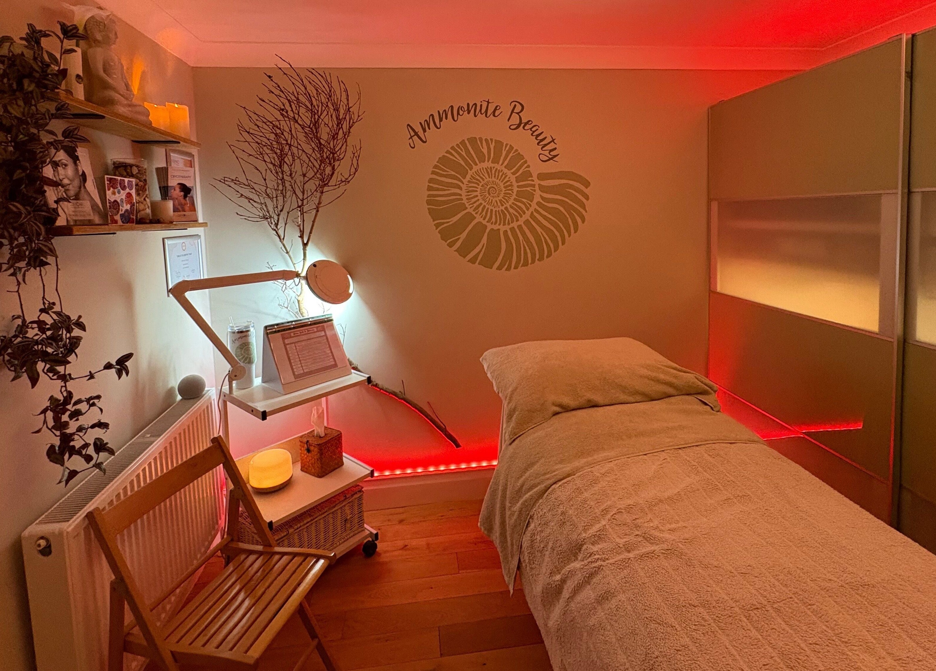 Relaxing treatment room at Ammonite Beauty in Bridport, England, GB, featuring soothing lighting and decor.