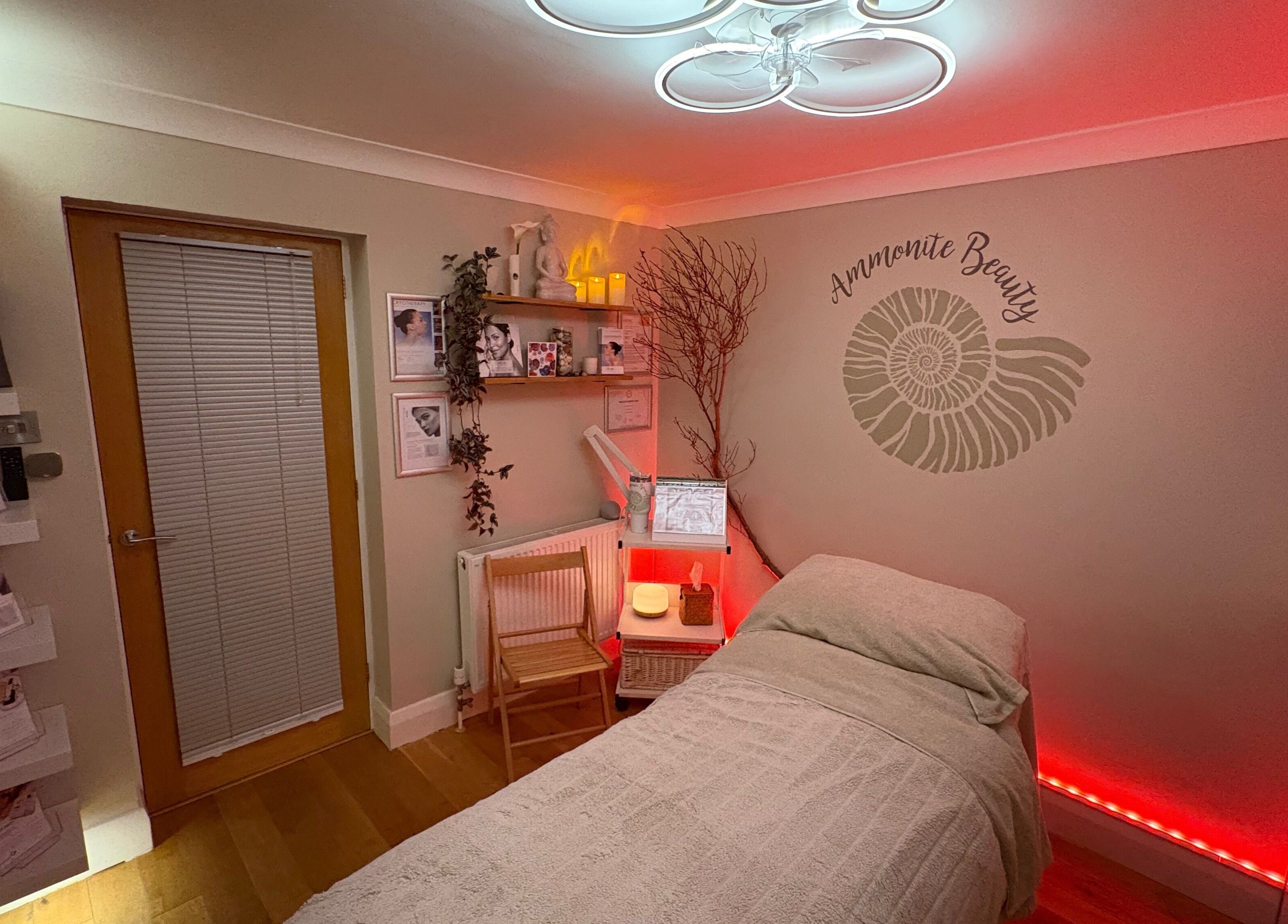 Cozy treatment room at Ammonite Beauty, Bridport, England, GB, with ambient lighting and calming decor.