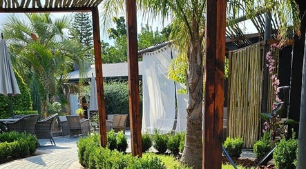 Lush garden view at Konanani Massage & Spa in Polokwane, Limpopo, ZA under a shaded patio.