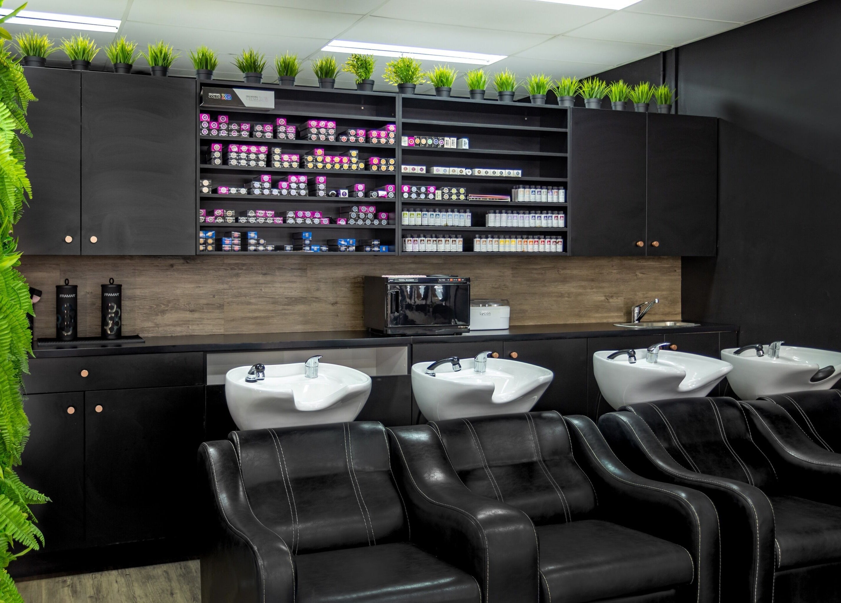 The Studio Hair & Tanning wash station with sleek black chairs in Deception Bay, Queensland, AU.
