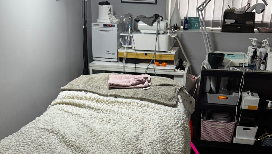 Cozy treatment room at Confidence Beauty in Peterborough, England, GB, featuring a plush treatment bed and modern equipment.
