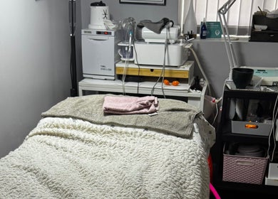 Cozy treatment room at Confidence Beauty in Peterborough, England, GB, featuring a plush treatment bed and modern equipment.