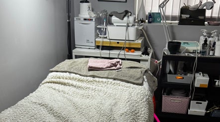 Cozy treatment room at Confidence Beauty in Peterborough, England, GB, featuring a plush treatment bed and modern equipment.
