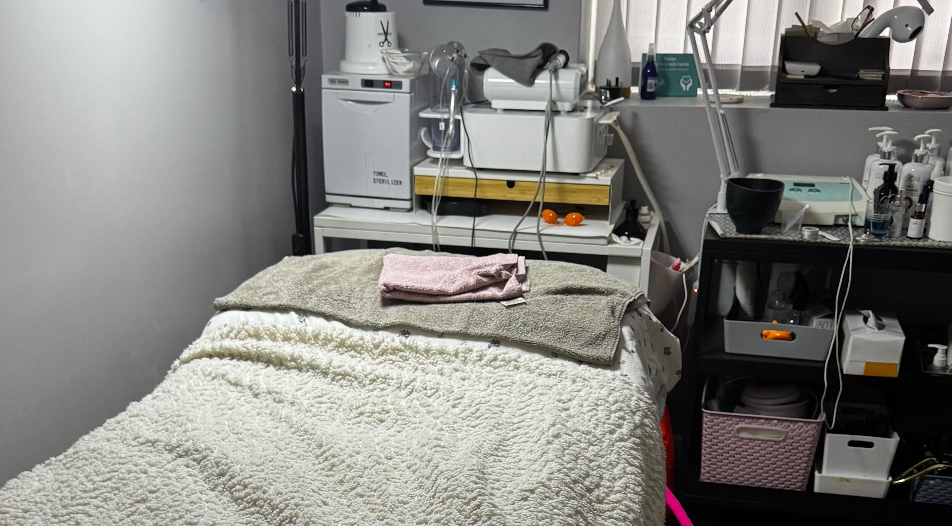 Cozy treatment room at Confidence Beauty in Peterborough, England, GB, featuring a plush treatment bed and modern equipment.