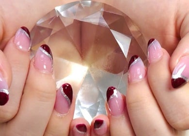 Elegant nail art with red tips at Pro Nails Salon, Winnipeg, Manitoba, CA, showcasing luxury and style.