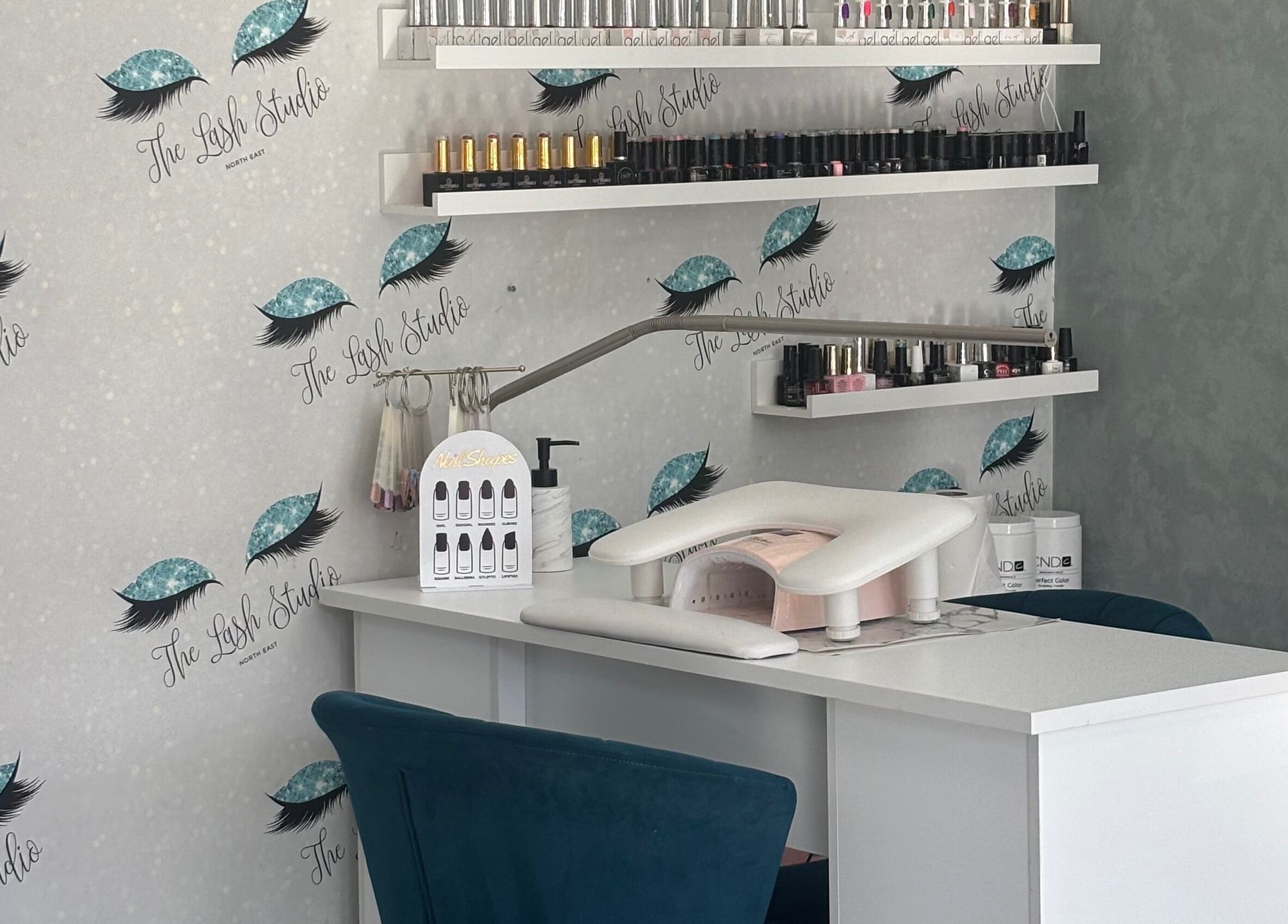 Nail station at The Lash Studio NE, Jarrow, England, GB, showcasing elegant decor with shelves of nail products.
