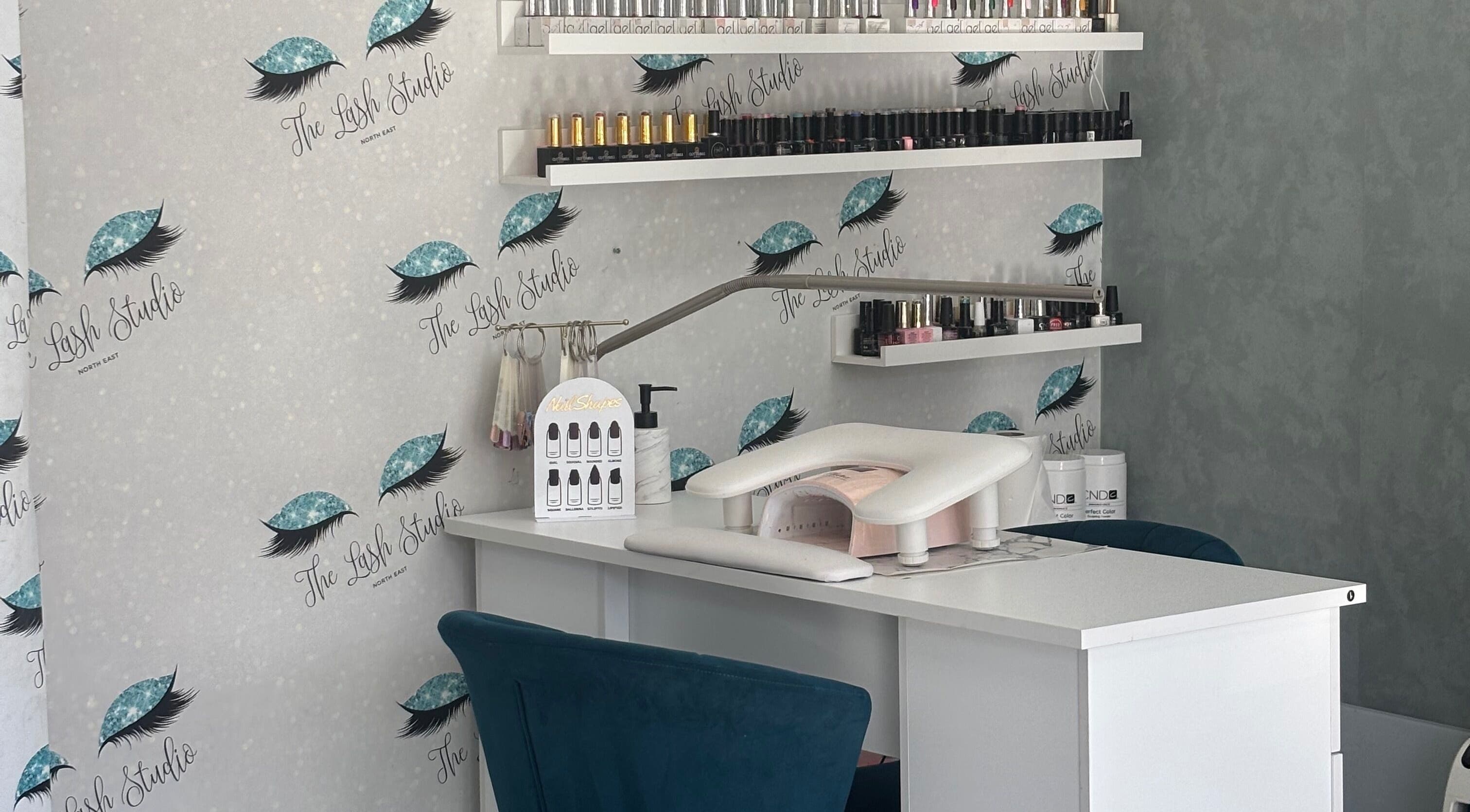 Nail station at The Lash Studio NE, Jarrow, England, GB, showcasing elegant decor with shelves of nail products.