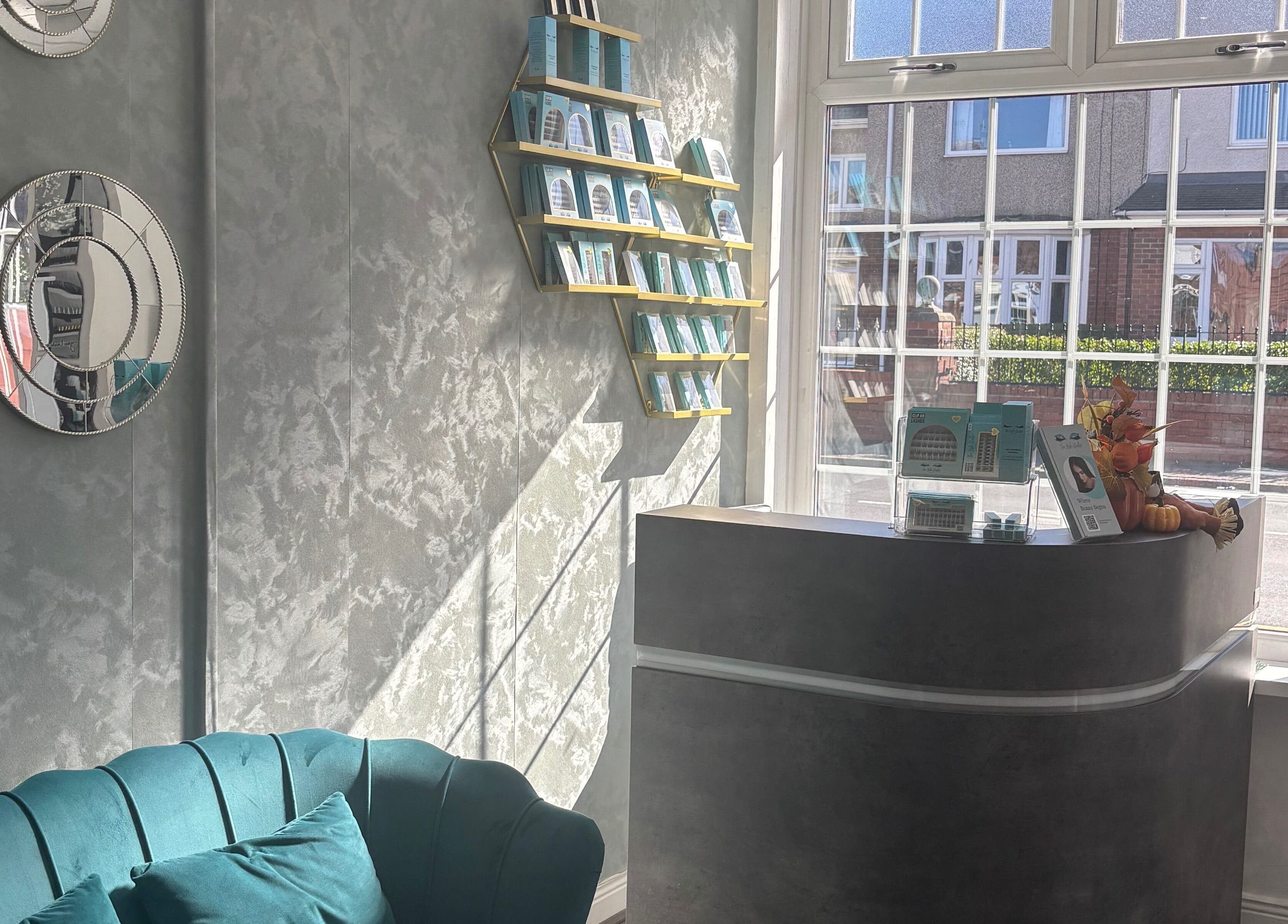 Modern interior at The Lash Studio NE, Jarrow, England, GB with teal sofa and decorative mirrors.