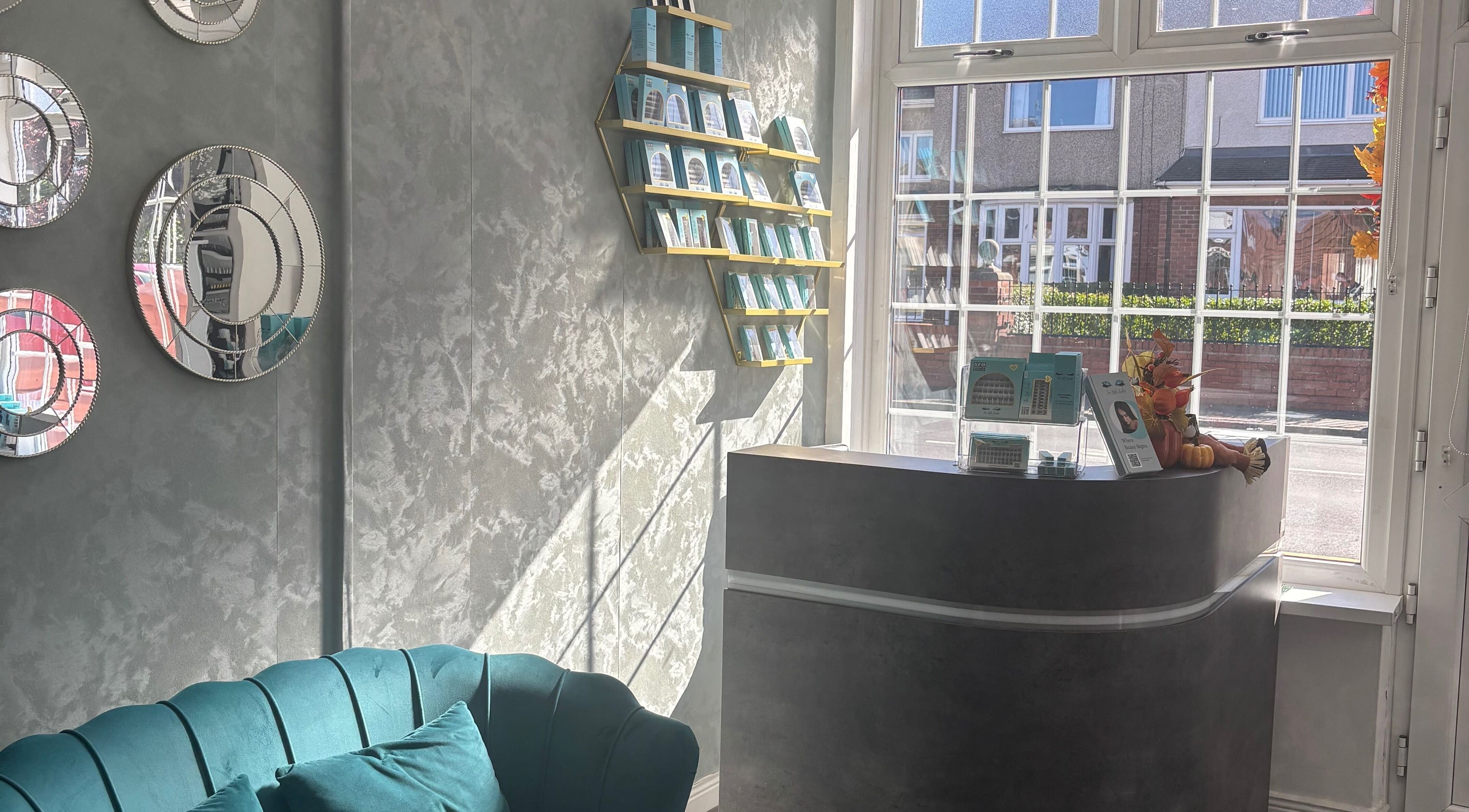 Modern interior at The Lash Studio NE, Jarrow, England, GB with teal sofa and decorative mirrors.