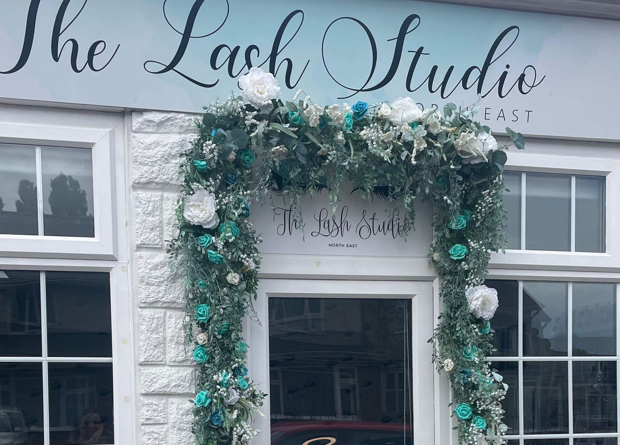 Entrance of The Lash Studio NE in Jarrow, England, adorned with lush floral wreath, showcasing elegance.