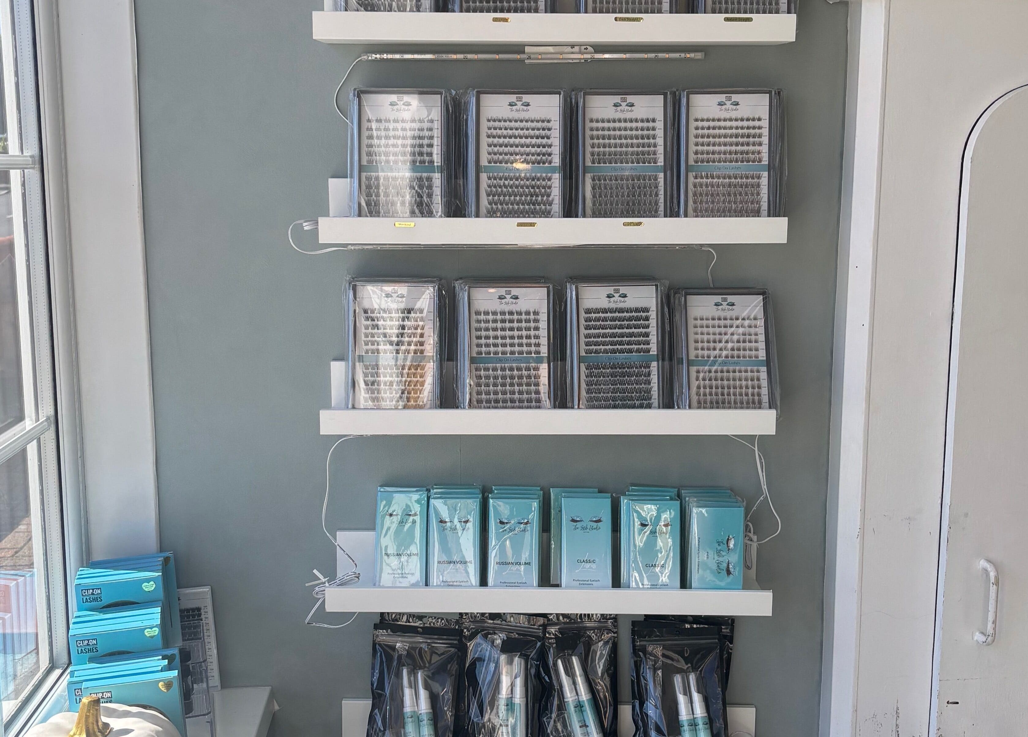 Lash products on sleek shelves at The Lash Studio NE in Jarrow, England, GB, showcasing stylish range.