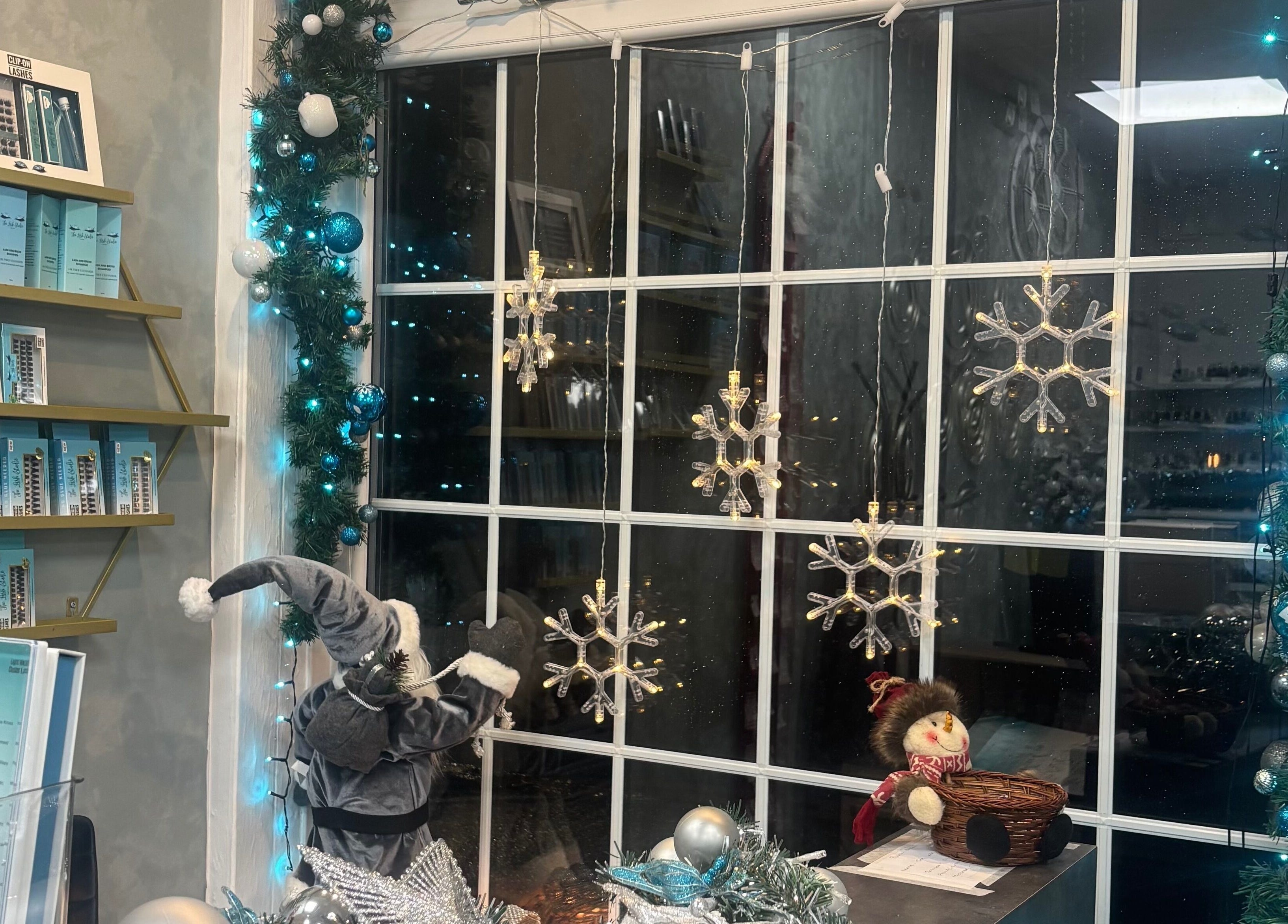 Festive window at The Lash Studio NE in Jarrow, England, GB adorned with snowflakes and holiday decor.