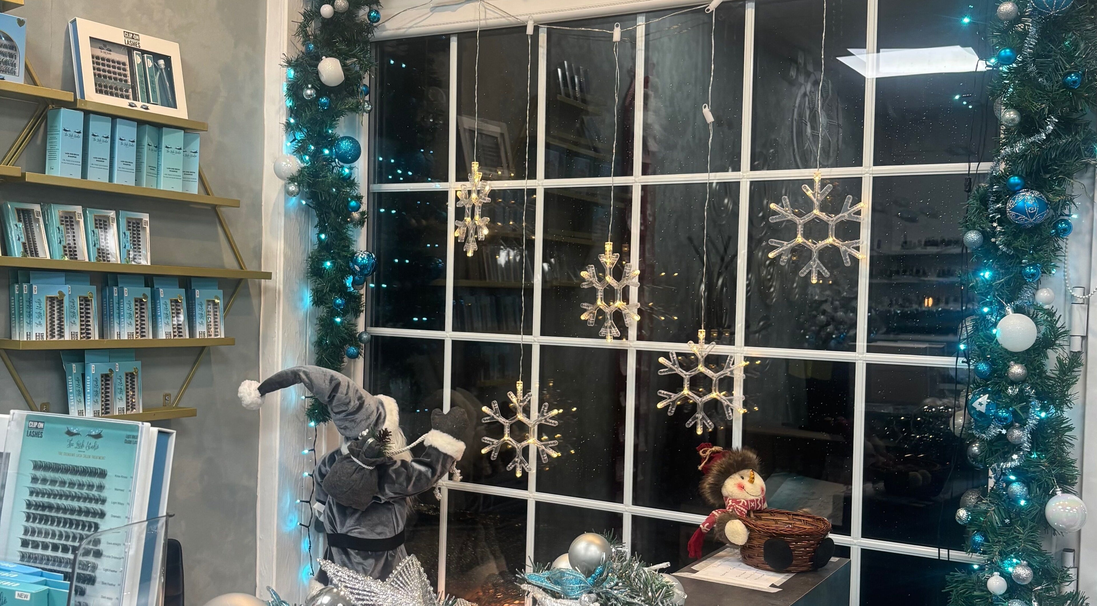 Festive window at The Lash Studio NE in Jarrow, England, GB adorned with snowflakes and holiday decor.