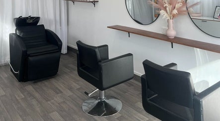 Modern salon interior at Brooke & Co Hair Salon in Brassall, Queensland, AU featuring sleek black chairs and mirrors.