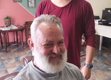 Customer enjoying a fresh trim at Tame Your Mane Barbershop, Cape Town, Western Cape, ZA.
