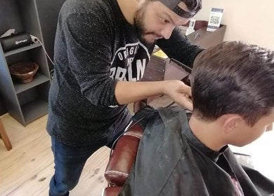 Barber crafts trendy cut at Tame Your Mane Barbershop, Cape Town, Western Cape, ZA.